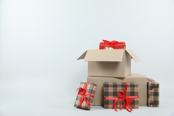Parcel with gift boxes on light background