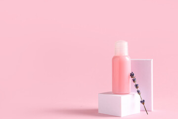 Decorative podiums with bottle of cosmetic product and lavender flowers on pink background