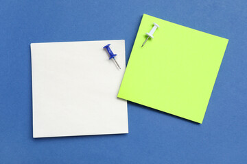 Paper notes with pins on blue background