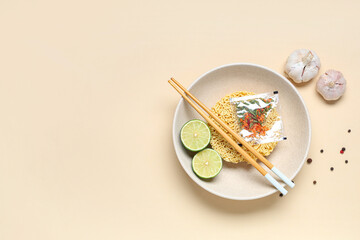 Bowl with raw instant noodles, different ingredients and chopsticks on beige background