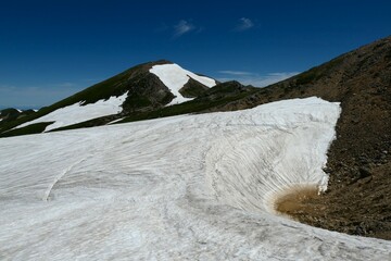 残雪豊富な千蛇ヶ池と大汝峰