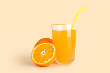 Glass of fresh orange juice on beige background