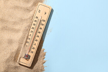 Weather thermometer and sand on color background