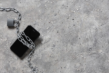 Padlock with chain and mobile phone on grunge background. Cyber security concept