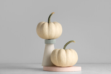 Decorative podiums with fresh pumpkins on grey background
