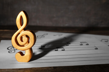 Note sign with music sheets on wooden table