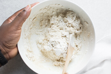 Overhead view of bread dough being mixed in a bowl , top view of homemade bread dough in a mixing bowl, process of making artisan bread