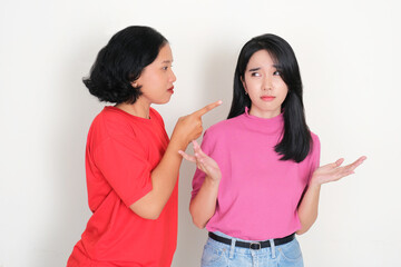 A woman blaming and pointing her friend with serious face expression
