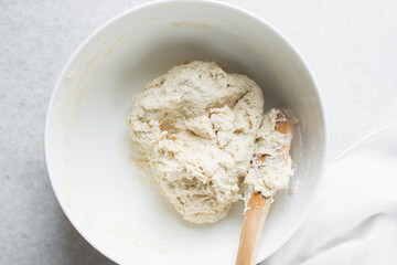 Overhead view of bread dough being mixed in a bowl , top view of homemade bread dough in a mixing bowl, process of making artisan bread