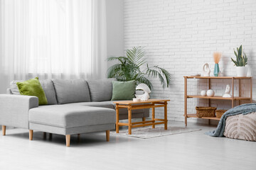 Interior of living room with sofa, table and shelf unit
