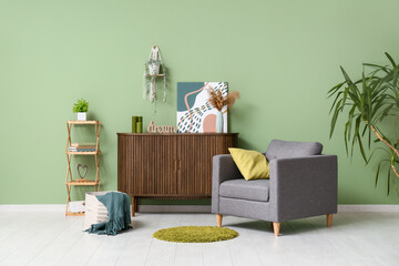 Interior of living room with armchair, commode and green plants