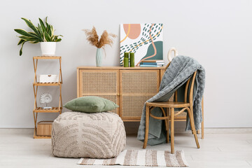 Interior of living room with chair, pouf and commode