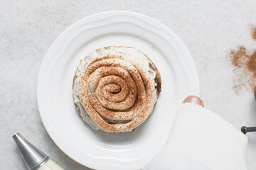 Overhead view of frosting coated cinnamon cookies, top view of cinnamon cookies with a vanilla cream frosting, process of making bakery style cookies