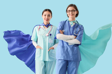 Female Asian doctors with superhero capes on blue background. International Nurses Day