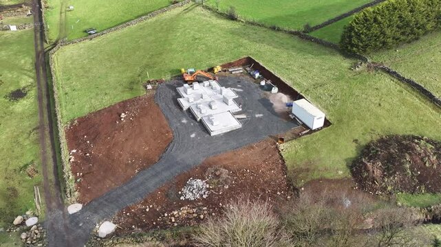 Aerial View of a digger at a building site constructing a new home in UK