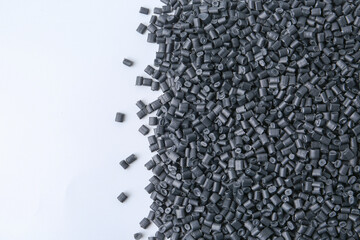 Pile of black plastic granules on white background, top view. Space for text