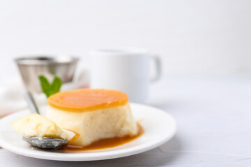 Tasty pudding with caramel sauce served on white textured table, closeup. Space for text