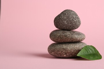 Stack of rocks on light pink background, space for text. Harmony and life balance