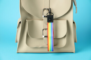 Backpack with keychain in LGBT colors on light blue background