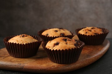 Delicious muffin with chocolate chips on table, closeup