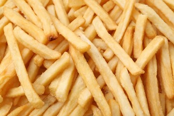 Pile of delicious French fries as background, closeup