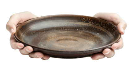 Two hands holding empty rustic ceramic plate on transparent background
