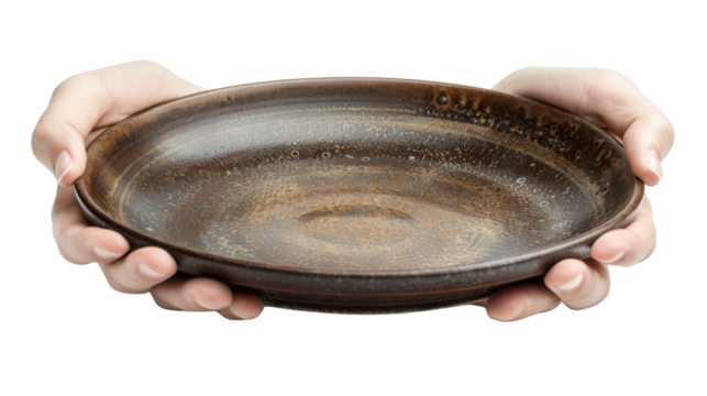 Two hands holding empty rustic ceramic plate on transparent background