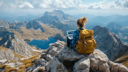 Mountain landscape with a person working on a laptop at an elevation during a clear day