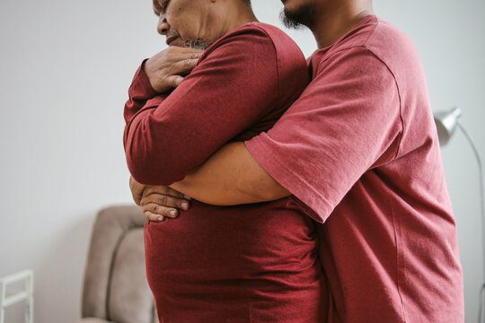 Guy Making The Heimlich Maneuver To Senior Man While He's Chocking