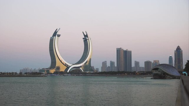 Crescent tower from Al Maha Island in Qatar, with a brightly colored sky before sunset