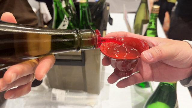 お猪口に日本酒を注ぐ男性の手