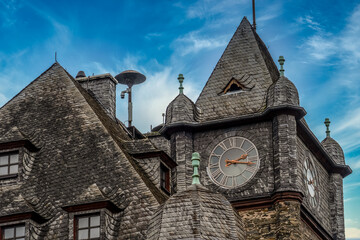 Historic city hall tower in Oberwesel Germany with clock and air raid siren against blue sky background