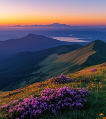 Serene Mountain Landscape at Sunrise with Colorful Wildflowers and Misty Horizon Overlooking a Lake and Distant Peaks in a Peaceful Natural Setting