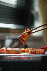 a piece of eel that is well-roasted with chopsticks on the stove.