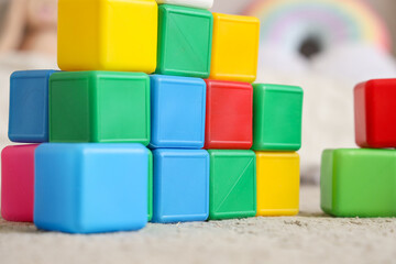 Colorful cubes on carpet in children's room, closeup