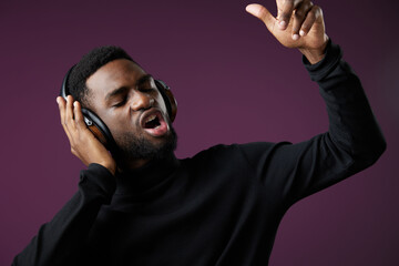 Male singer wearing headphones passionately enjoying music with a purple background, portraying enthusiasm and creativity in a modern style