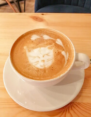 a cup of aromatic coffee with a cute cat's face on the surface