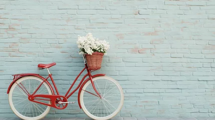Fototapete Vintage Bicycle with Blooms: A classic red bicycle with a charming wicker basket overflowing with fresh flowers is placed against a textured, weathered blue brick wall. © pattozher