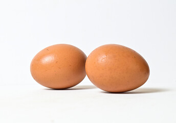 Two fresh raw chicken eggs isolated on white background. Close up view. Side view.