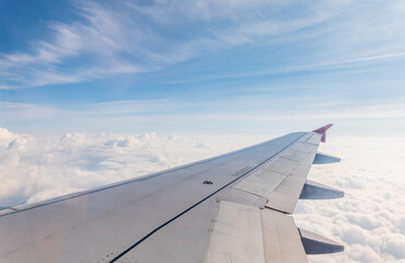 Obraz premium View from the airplane window at a beautiful cloudy sky and the airplane wing