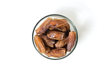 Top view of kurma tunisia or sweet dried dates palm fruits in a little glass bowl. Isolated on white background. clipping path. Flat lay. High angle, above.