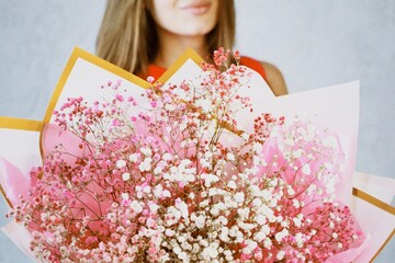 Close-up of a woman holding a beautiful bouquet of pink baby's breath flowers