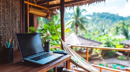 Laptop open on balcony desk, forest background