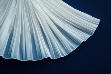 Elegant white dress with graceful pleats displayed on a deep blue background captivating attention in a fashion setting