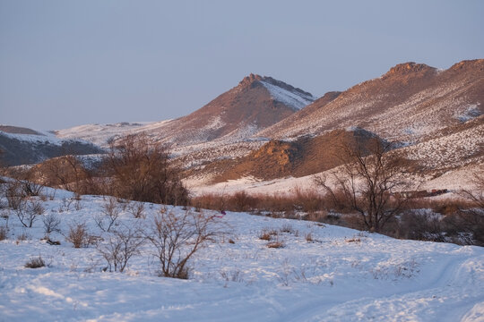 Nature landscape with steppe mountains in snow at sunset in winter