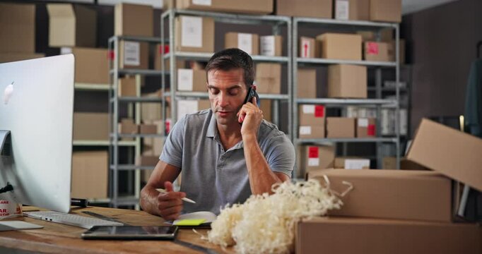 Small business, phone call and man with order, boxes and preparing for delivery with notes and logistics. Warehouse, entrepreneur and person with stock for supply chain, communication and online shop
