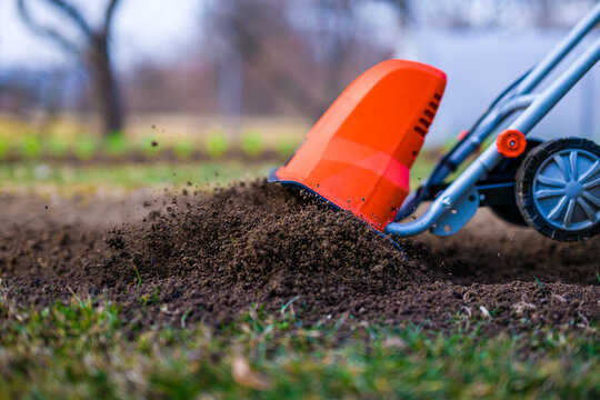Garden tiller, rotary tiller, mini cultivator or rotavator. Tillers break up compacted soil, improve its structure and aeration. Preparing garden beds for planting.