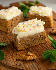Small slices of carrot cake with a cream cheese frosting and caramel balls for decoration.