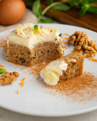 Small slices of carrot cake with a cream cheese frosting and caramel balls for decoration.