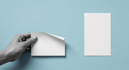 A Hand Gently Unveiling A Blank Note, A Silent Story Of Potential And New Beginnings Against A Serene Blue Backdrop